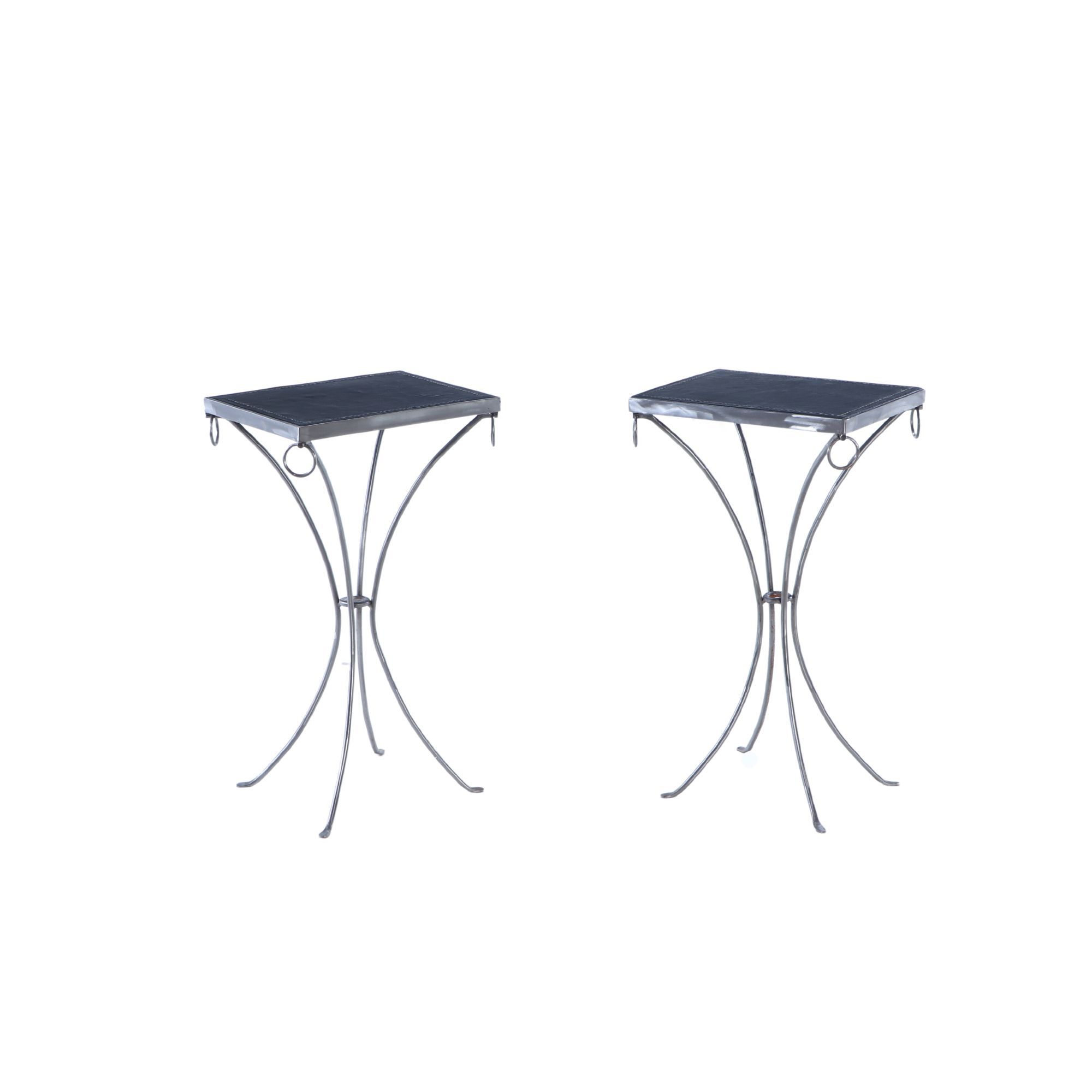 A pair of polished iron drinks tables. Contemporary.